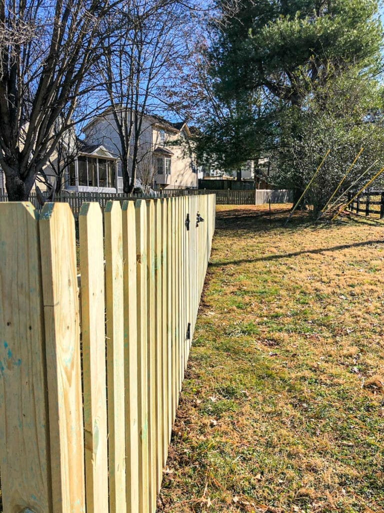 Wood privacy fence in residential yard with grass and trees, showcasing professional installation by Home Deck & Fence in Middle Tennessee.