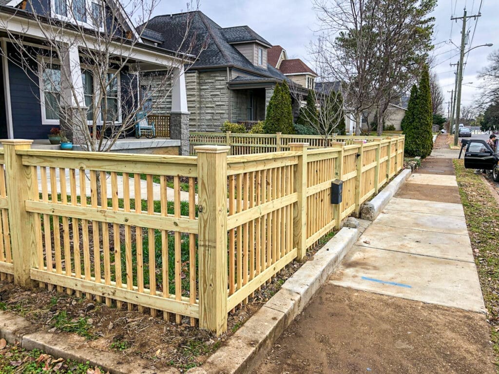 Newly installed wooden fence surrounding a front yard in Middle Tennessee, showcasing a well-maintained outdoor structure that enhances curb appeal and security for homeowners.