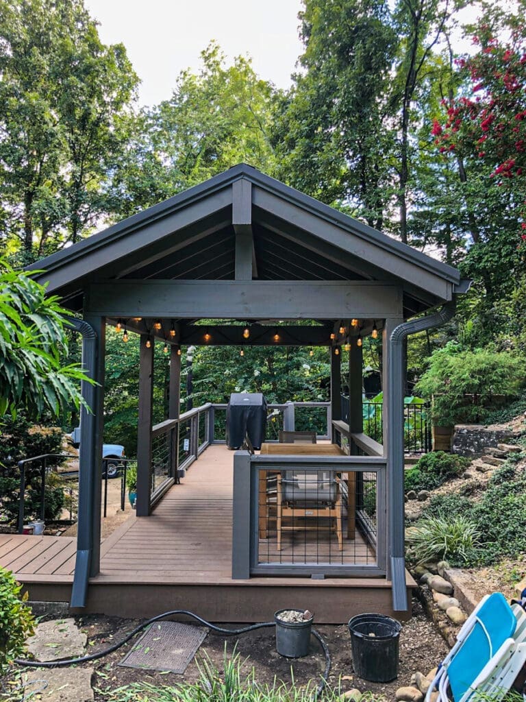 Custom outdoor gazebo with string lights, surrounded by greenery, showcasing durable decking and fencing in a residential backyard in Middle Tennessee.