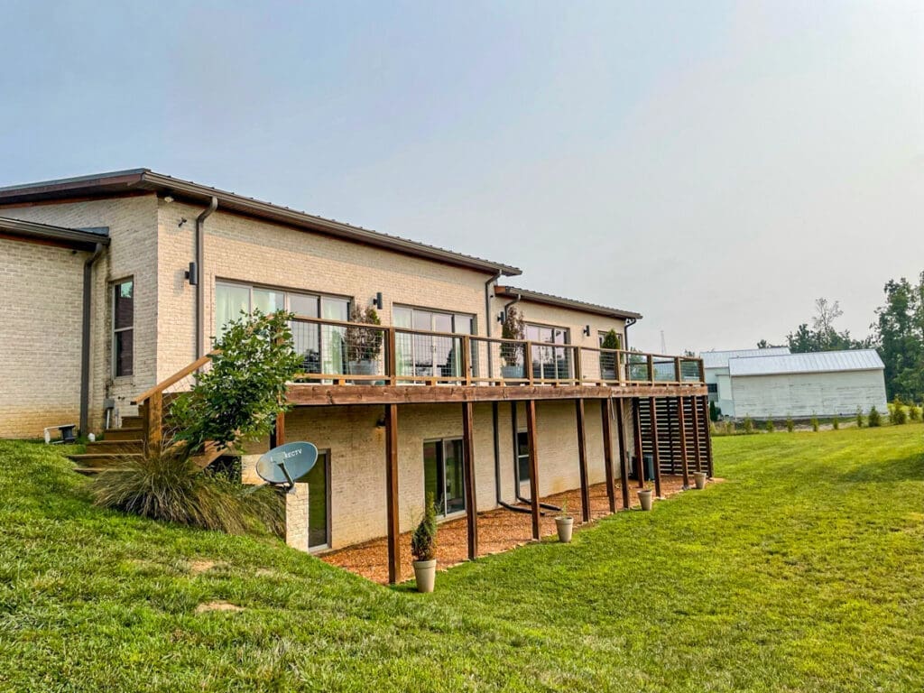 Home Deck and Fence project in Dickson County, Tennessee, featuring a modern two-story house with a wooden deck, landscaped yard, and outdoor seating area.