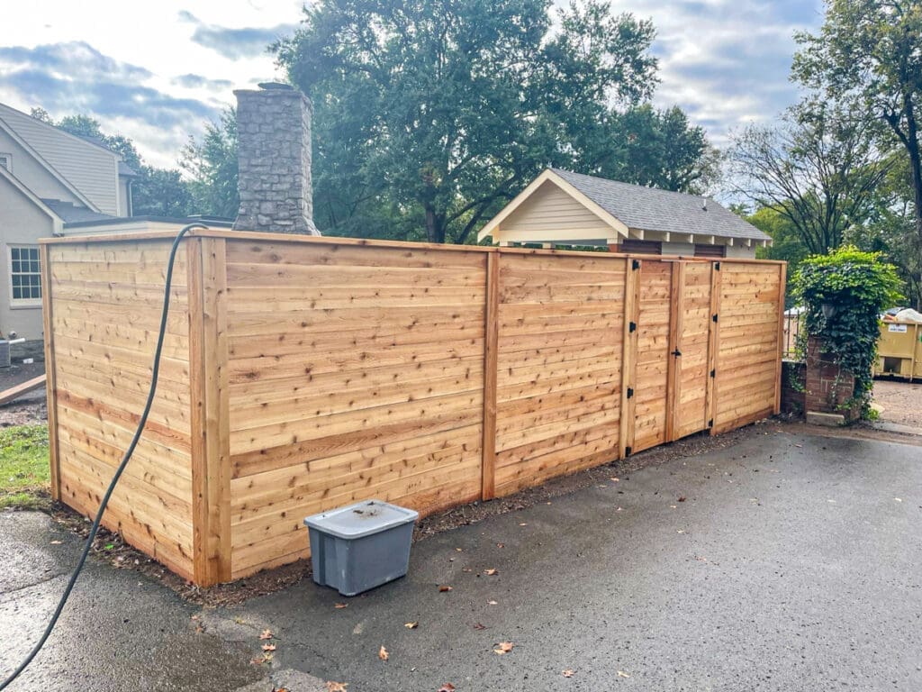 Wooden privacy fence installation in Middle Tennessee, featuring a sturdy design and dual gates, enhancing outdoor space aesthetics and security.