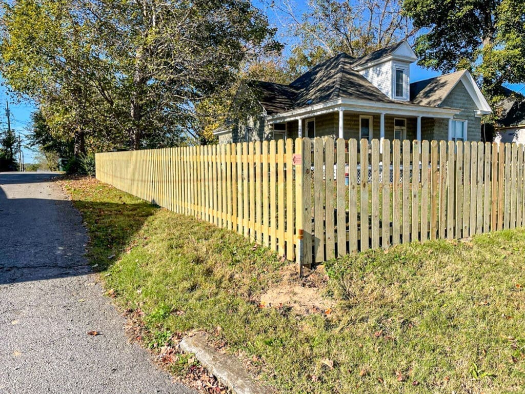 Newly installed wooden picket fence surrounding a residential yard in Middle Tennessee, showcasing privacy and style for homeowners in Dickson County.