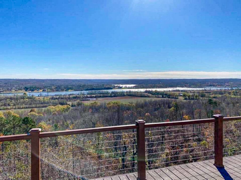 Scenic view of Middle Tennessee landscape from a deck, showcasing rolling hills, a river, and colorful autumn foliage, emphasizing outdoor living and custom structures by Home Deck & Fence Co.