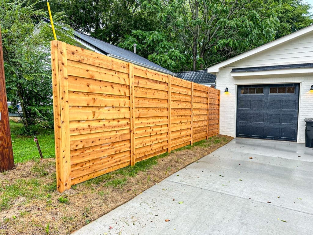 Wooden privacy fence installed beside a driveway, showcasing quality craftsmanship and enhancing outdoor space in Middle Tennessee.