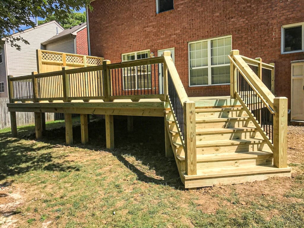 Custom wooden deck with stairs and railings in a residential backyard, showcasing quality craftsmanship by Home Deck & Fence Co. in Middle Tennessee.
