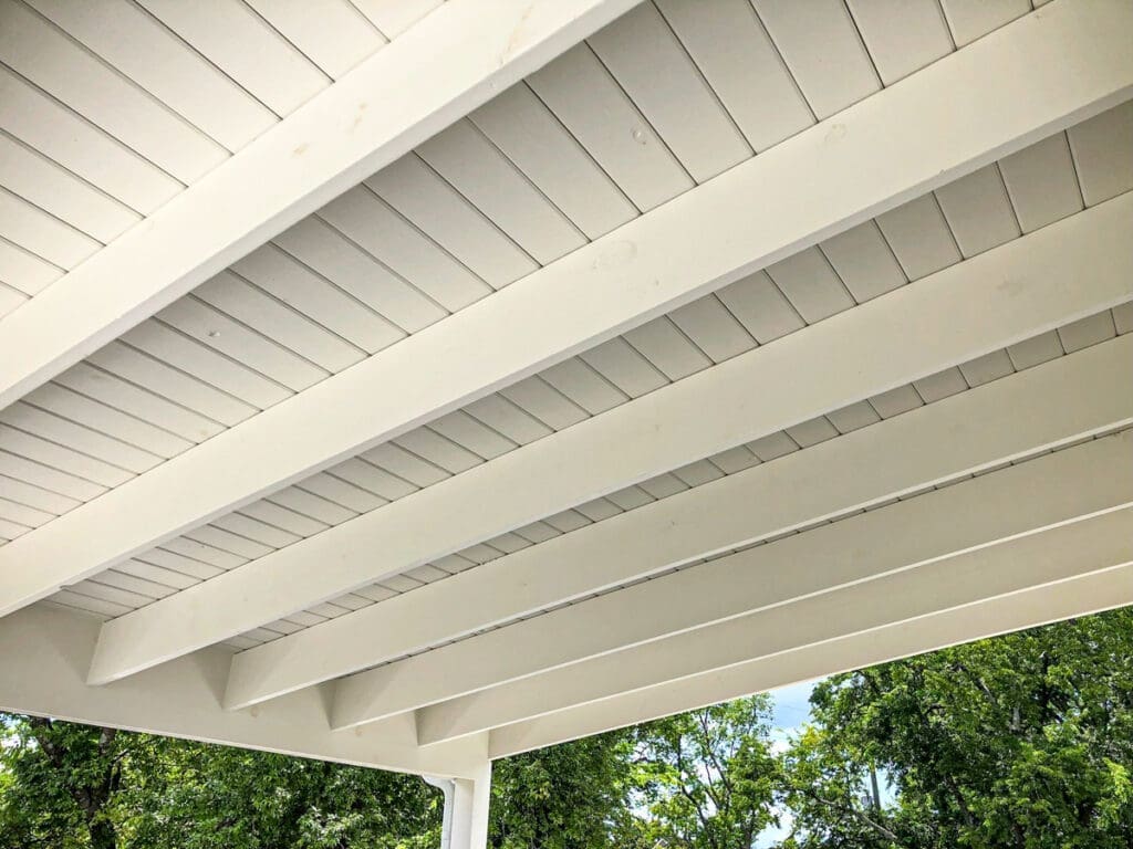 Covered porch ceiling with white beams and panels, showcasing craftsmanship by Home Deck and Fence, emphasizing quality construction for outdoor spaces in Middle Tennessee.
