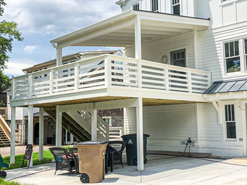 Custom outdoor deck with white railing and shaded area, enhancing residential property in Dickson County, Tennessee.