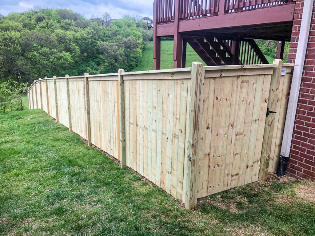 New wooden fence installed in backyard of home in Middle Tennessee, showcasing sturdy construction and natural wood finish, enhancing outdoor space and security.
