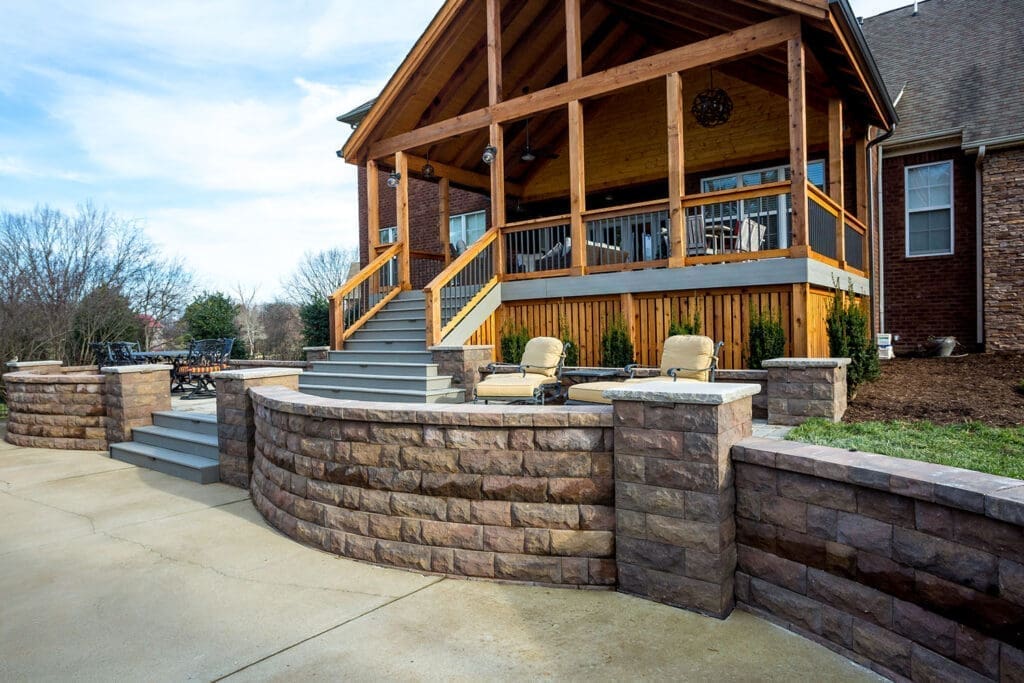 Outdoor deck and seating area with stone wall, showcasing professional craftsmanship by Home Deck & Fence Co. in Middle Tennessee.