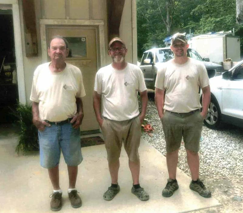Three generations of contractors from Home Deck and Fence Company, standing together outside their workplace in Middle Tennessee, showcasing family legacy and craftsmanship in outdoor construction.