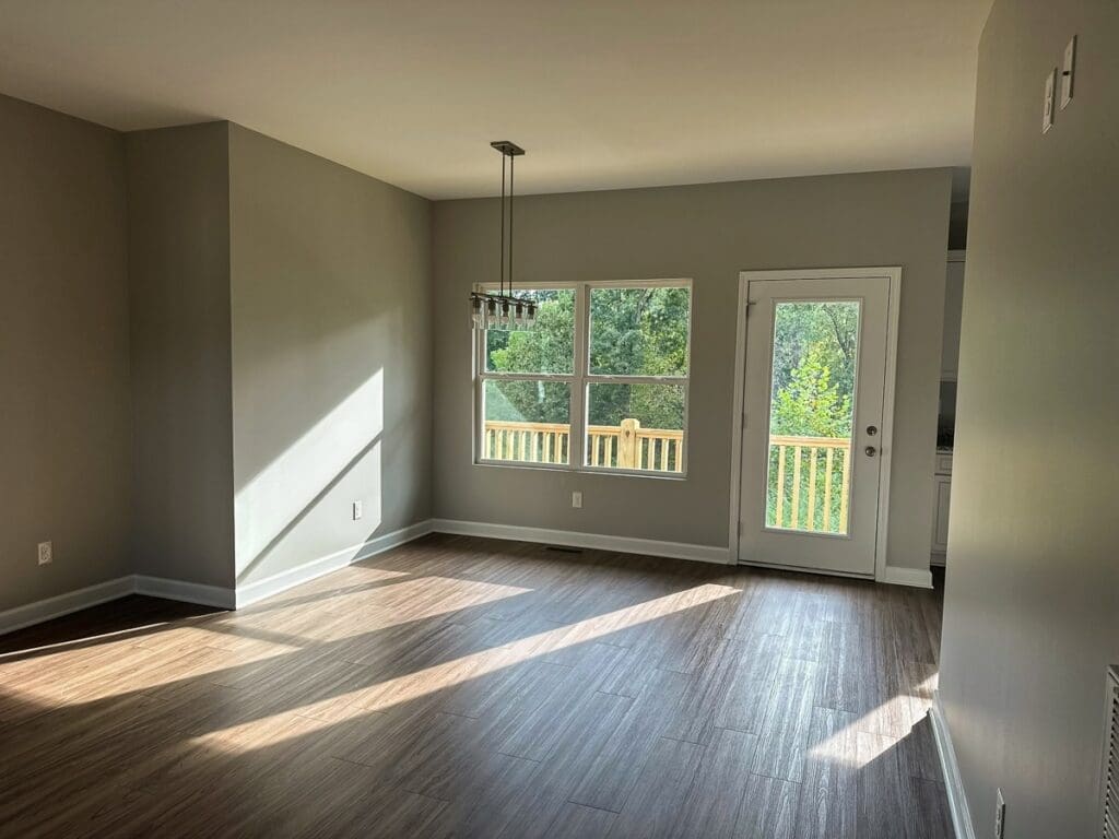 Bright, spacious interior of a duplex home featuring large windows, modern lighting fixture, and wooden flooring, showcasing the quality construction by HDF Builders in Middle Tennessee.