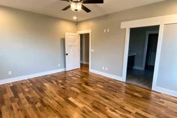 Empty interior room showcasing hardwood flooring, ceiling fan, and doorways leading to adjacent spaces, reflecting custom home design by HDF Builders in Middle Tennessee.