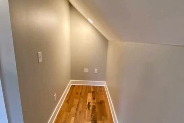 Narrow hallway with sloped ceiling, featuring hardwood flooring and neutral-colored walls, showcasing custom home interior design by HDF Builders in Middle Tennessee.