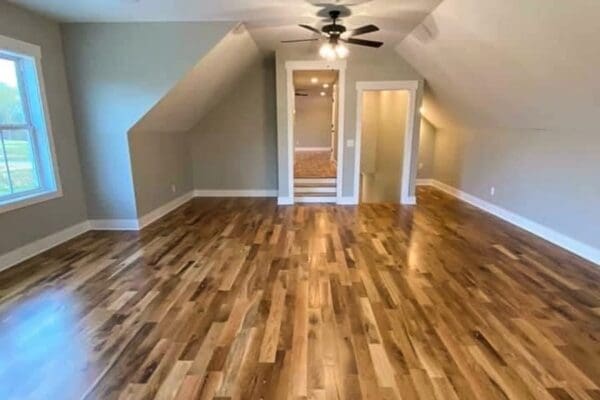 Spacious custom home interior with hardwood flooring, sloped ceiling, and natural light from window, showcasing design potential for Middle Tennessee homes.
